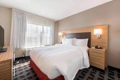 a hotel room with a large bed and a window at TownePlace Suites by Marriott Greensboro Coliseum Area in Greensboro