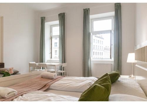 a bedroom with a large bed and two windows at Super helles Apartment - perfect for Longstays in Vienna