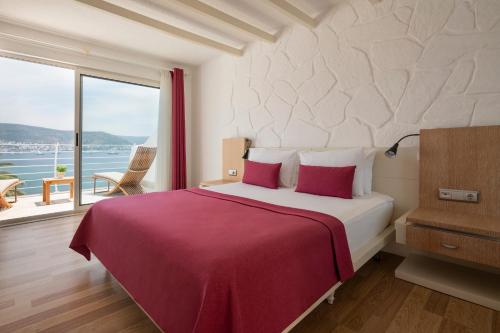 a bedroom with a large bed with a large window at Prive Hotel Bodrum - Adult Only in Bodrum City
