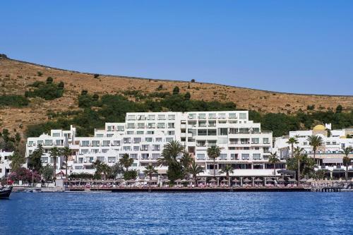 a large white building next to a body of water at Prive Hotel Bodrum - Adult Only in Bodrum City