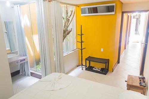 1 dormitorio con cama y pared amarilla en Casa de Praia em Morro de São Paulo (Gamboa), en Gamboa