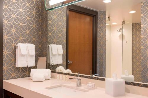 y baño con lavabo y espejo. en Courtyard by Marriott Waterloo Cedar Falls, en Waterloo