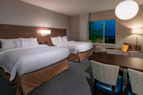 pokój hotelowy z 2 łóżkami, stołem i krzesłami w obiekcie TownePlace Suites by Marriott Leavenworth w mieście Leavenworth