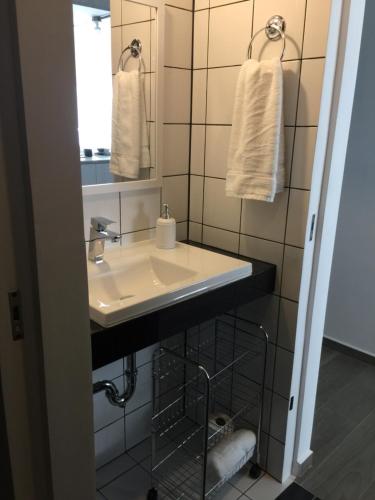 a bathroom with a sink and a mirror and towels at Apartamento moderno 2 habitaciones y 2 baños area Cayala y Embajada USA in Guatemala