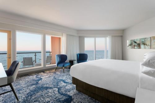 a hotel room with a bed and a view of the ocean at Delta Hotels by Marriott Virginia Beach Waterfront in Virginia Beach