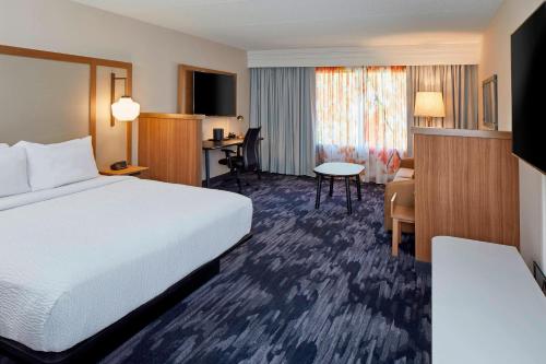 Fairfield Inn & Suites by Marriott Albany Airport في ألباني: غرفة في الفندق مع سرير ومكتب