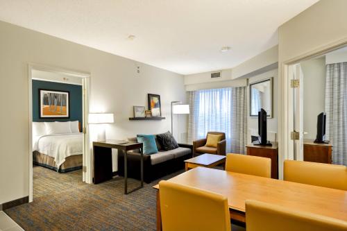 a hotel room with a bed and a dining room at Residence Inn Lexington South Hamburg Place in Lexington