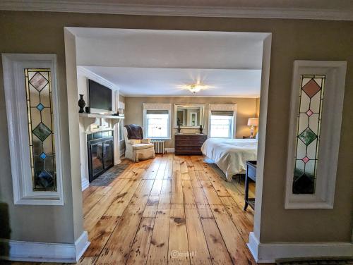a large room with a bed and a fireplace at Cromwell Manor Inn in Cornwall-on-Hudson