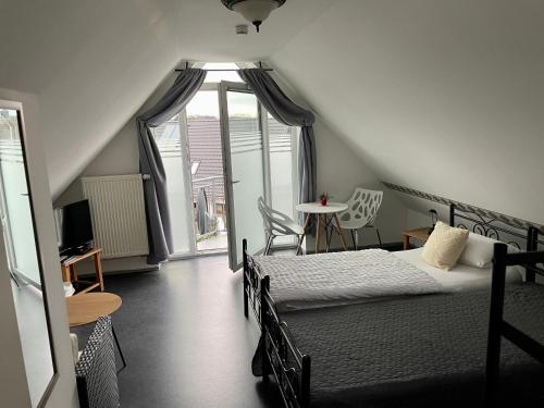 a bedroom with two beds and a window and a table at Gästehaus Vigliarolo in Elmshorn