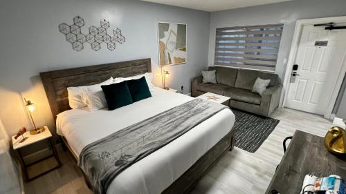 a bedroom with a large bed and a couch at Oceano Suites Daytona Beach in Daytona Beach