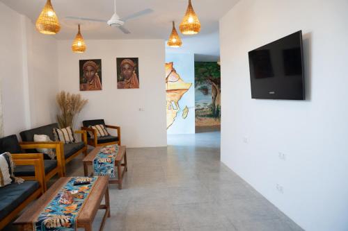 a living room with couches and a flat screen tv at Haber Hotel & SPA in Matemwe