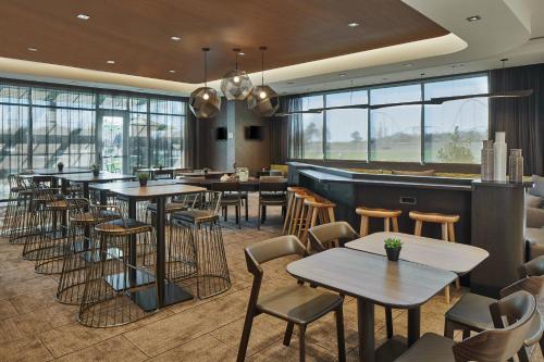 a restaurant with tables and chairs and a bar at SpringHill Suites Charlotte at Carowinds in Charlotte