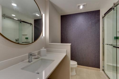 a bathroom with a sink and a mirror and a toilet at Fairfield Inn & Suites Warsaw in Warsaw