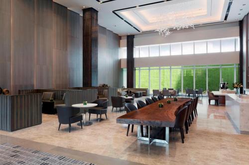 a restaurant with tables and chairs and a large window at Clark Marriott Hotel in Clark