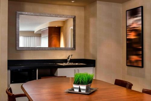 a dining room with a table and a mirror at Courtyard by Marriott Kansas City Shawnee in Shawnee