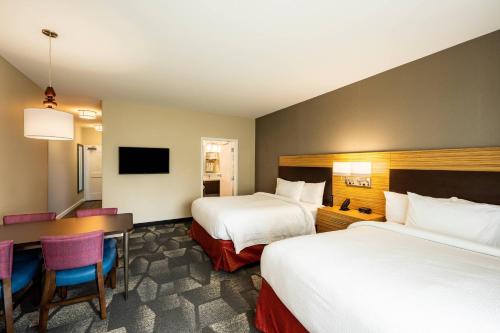 a hotel room with two beds and a desk at TownePlace Suites by Marriott Fort Mill at Carowinds Blvd in Fort Mill