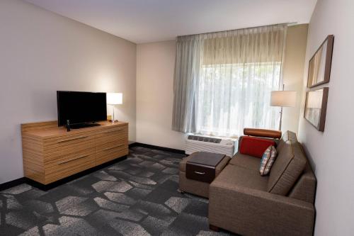 a living room with a couch and a flat screen tv at TownePlace Suites by Marriott Fort Mill at Carowinds Blvd in Fort Mill