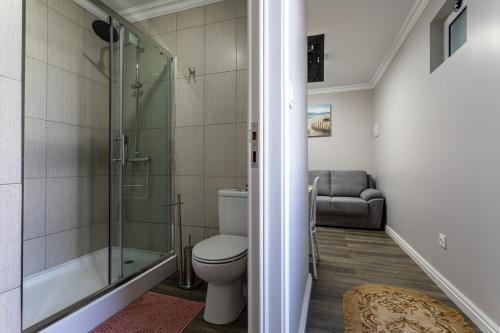 a bathroom with a toilet and a glass shower at Oásis Fonte Grande in Santo António