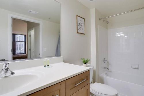een badkamer met een wastafel, een toilet en een spiegel bij Awesome 2 BR Apartmetn At Pentagon City with Gym in Arlington