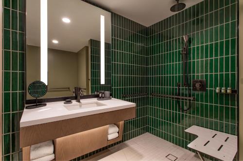 a green tiled bathroom with a sink and a shower at W Nashville in Nashville