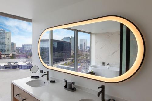 a bathroom with a mirror and a sink and a window at W Nashville in Nashville
