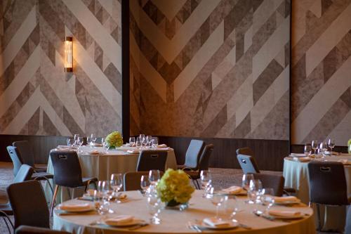 a dining room with tables and chairs with wine glasses at W Nashville in Nashville