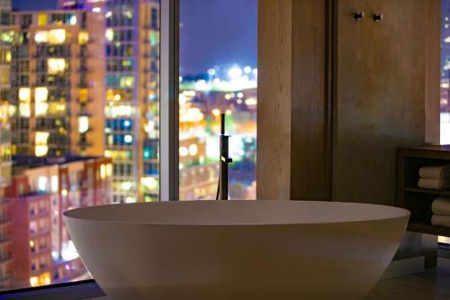 a white bath tub in a bathroom with a window at W Nashville in Nashville
