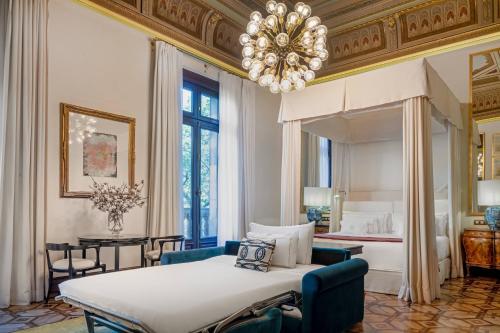 sypialnia z dużym łóżkiem i żyrandolem w obiekcie Cotton House Hotel, Autograph Collection w Barcelonie