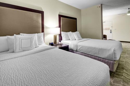 ein Hotelzimmer mit 2 Betten mit weißer Bettwäsche in der Unterkunft SpringHill Suites Port Saint Lucie in Port Saint Lucie