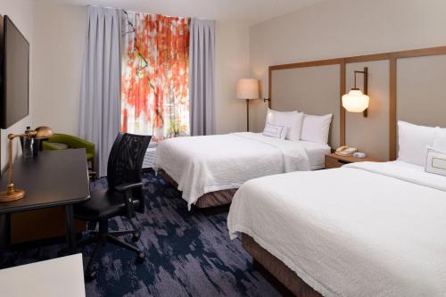a hotel room with two beds and a desk at Fairfield Inn Arlington Near Six Flags in Arlington