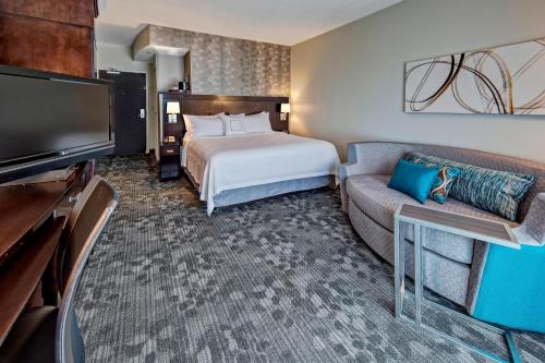 a hotel room with a bed and a couch at Courtyard by Marriott Midland in Midland