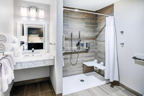 uma casa de banho com um chuveiro e um lavatório. em TownePlace Suites Dallas Plano/Richardson em Plano