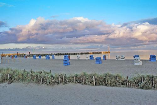 a group of blue chairs sitting on the beach at Ferienwohnung mit neuer Küche u Bad - W-LAN in Damp