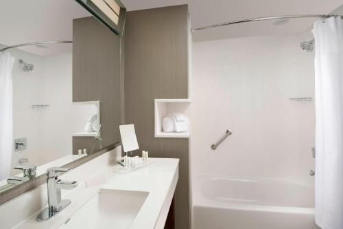 a white bathroom with a sink and a shower at Courtyard by Marriott Nashville SE/Murfreesboro in Murfreesboro
