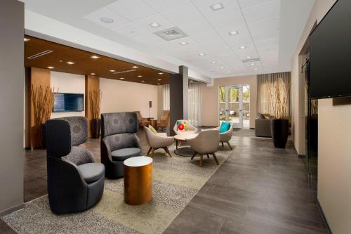a lobby with chairs and a table in a room at Courtyard by Marriott Nashville SE/Murfreesboro in Murfreesboro