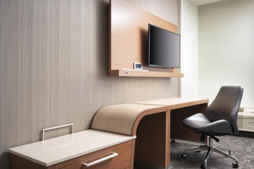 a room with a desk with a monitor and a chair at Courtyard by Marriott Nashville SE/Murfreesboro in Murfreesboro