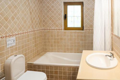 La salle de bains est pourvue d'une baignoire, de toilettes et d'un lavabo. dans l'établissement Casa Rina, à Lagoa