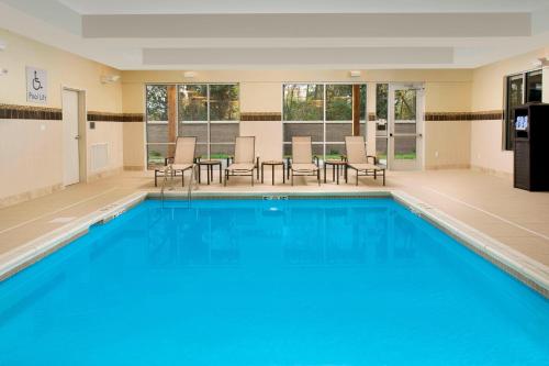 a large swimming pool with blue water in a building at Courtyard by Marriott Nashville SE/Murfreesboro in Murfreesboro