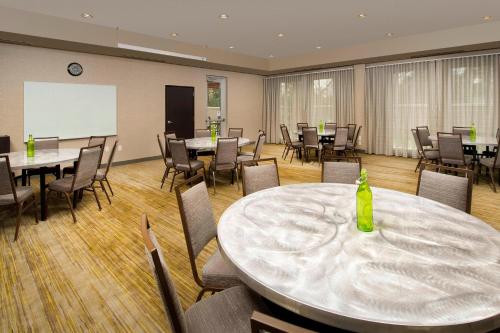 a conference room with tables and chairs and a whiteboard at Courtyard by Marriott Nashville SE/Murfreesboro in Murfreesboro
