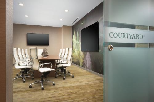 a conference room with a table and chairs and a tv at Courtyard by Marriott Nashville SE/Murfreesboro in Murfreesboro