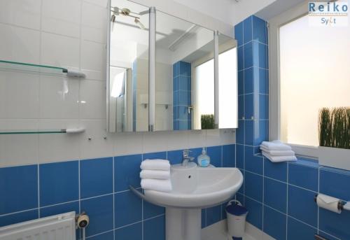 a blue bathroom with a sink and a mirror at Margaretheneck, sehr strandnah und zentral in Westerland (Sylt)