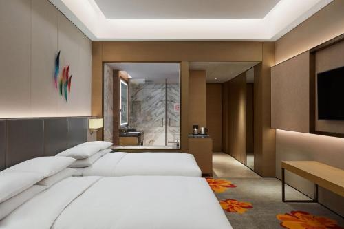 a hotel room with two beds and a flat screen tv at Sheraton Beijing Lize Hotel in Beijing