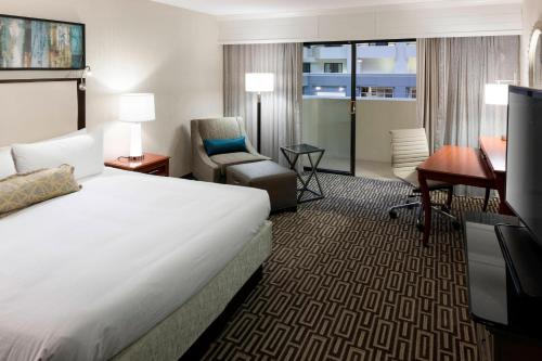 Habitación de hotel con cama, silla y escritorio. en Fairfax Marriott at Fair Oaks, en Fairfax