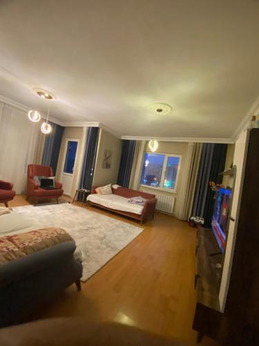 ein großes Wohnzimmer mit einem Sofa und einem TV in der Unterkunft İstanbul Otel Süit in Istanbul