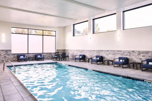 a large swimming pool with chairs and windows at AC Hotel by Marriott Bridgewater in Bridgewater