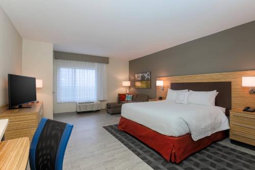 een hotelkamer met een bed en een flatscreen-tv bij TownePlace Suites by Marriott McAllen Edinburg in Edinburg