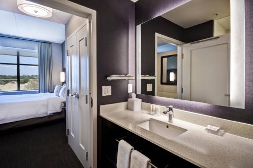 baño con lavabo, espejo y cama en Residence Inn by Marriott Cincinnati Northeast/Mason, en Mason