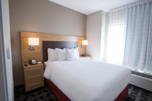 a bedroom with a large white bed and a window at TownePlace Suites by Marriott Southern Pines Aberdeen in Aberdeen