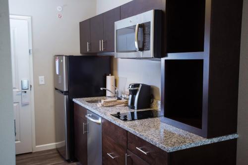 a kitchen with a sink and a refrigerator at TownePlace Suites by Marriott Southern Pines Aberdeen in Aberdeen