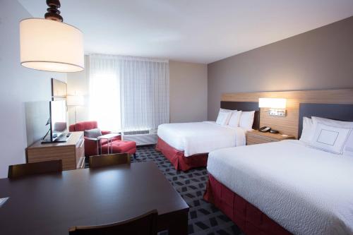 アバディーンにあるTownePlace Suites by Marriott Southern Pines Aberdeenのベッド2台とデスクが備わるホテルルームです。